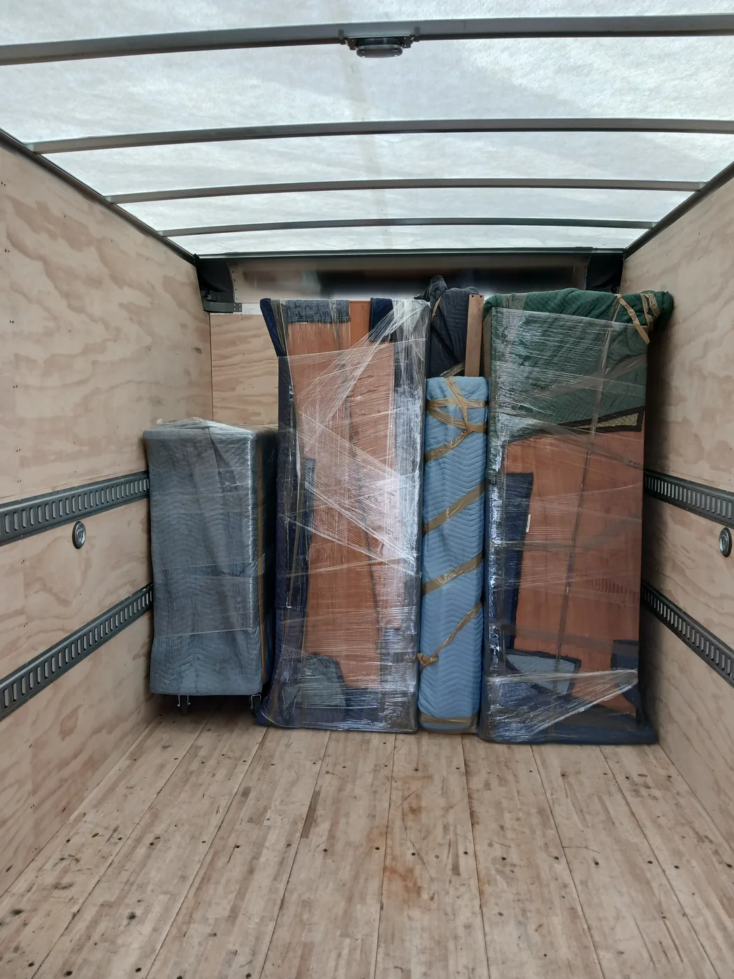Furniture wrapped and strapped inside a moving truck.