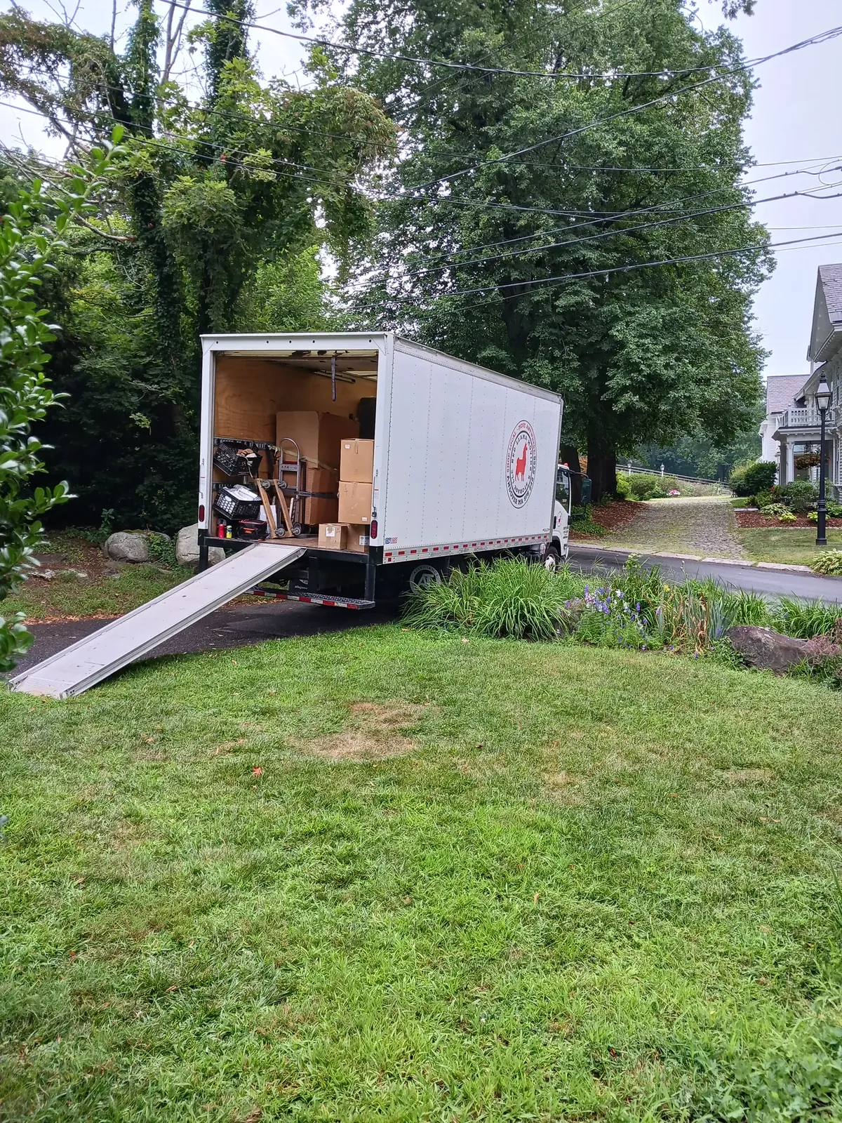 Red Llama moving truck with its loading ramp open.