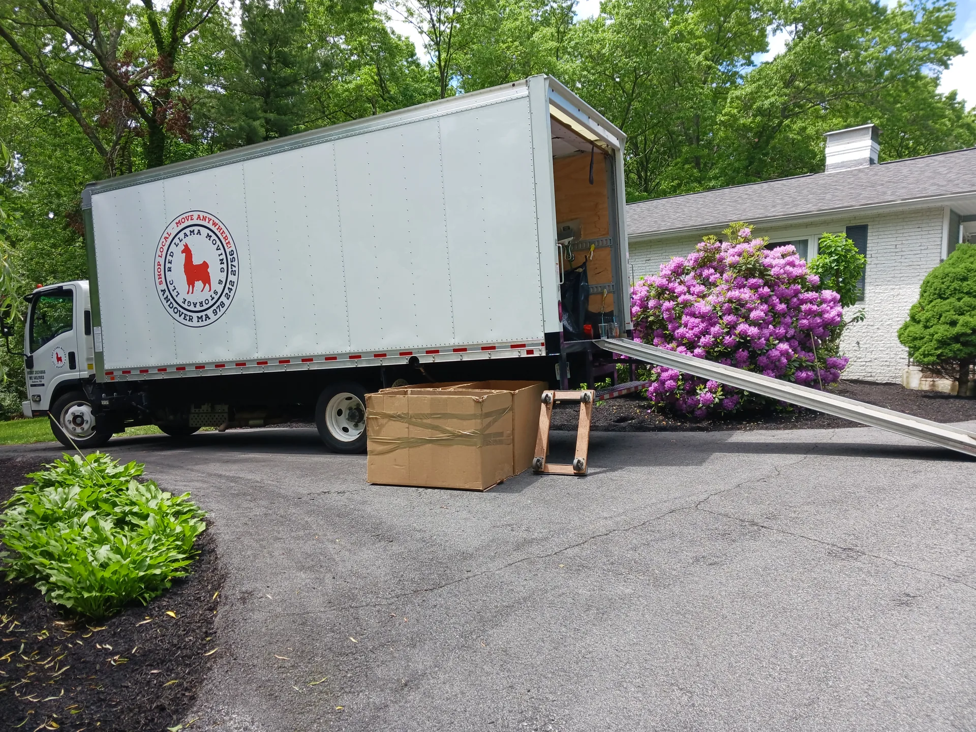 Red Llama moving truck positioned at a residential driveway.